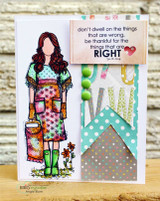 Card with Natalie colored in bright patterned pink, aqua and orange with green rain boots, beside the gratitude sentiment on a label with a red heart and aqua chevron strips.