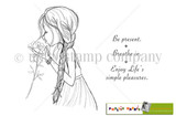 Line-art red rubber stamp of a girl with a long braid smelling a rose, with 'Be present. Breathe in. Enjoy life's simple pleasures.'