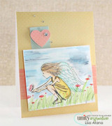 A pale yellow card with the winged girl watercolored in soft blue and cream in a meadow, with a small heart tag on a blue strip.