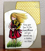 Card with the Face the Sunshine red rubber set: a girl in a red dress holding sunflowers beside 'Keep your face to the sunshine and you cannot see a shadow. -Helen Keller'.