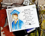 Grad in a blue gown on a journaling card, 'Behind you all your memories, before you all your dreams.'