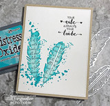 Card with two teal feather images stamped over text on a white panel, a sentiment at the top about your vibe attracting your tribe, with Distress Oxide ink alongside.
