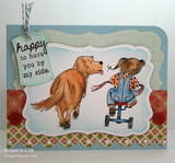 Card with the golden retriever and the pigtailed girl in blue overalls on a tricycle inside a scalloped sky-blue frame, with a 'happy to have you by my side.' tag tied on with twine