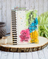 Card with Wren Girl stamped in black over bright pink, blue, green and yellow watercolor blooms beside the 'May your heart be Brave your mind fierce and your spirit Free.' sentiment and a black and white striped border