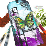 Mixed-media tag with an iridescent butterfly over black film-strip and grid grunge with 'Life's biggest adventure.'