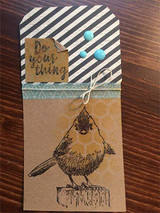 Kraft treat bag topped with a black striped tag, the songbird stamped in soft grey with a small 'Do your thing' circle tag and aqua enamel dots.