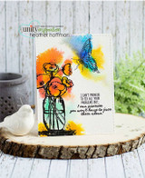 Card on a wood slice beside a white bird, the jar of poppies coloured in orange and yellow with a rainbow splashed background and a butterfly in blue, with the promise to face them together sentiment.