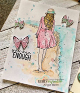 Card with the girl in a pink outfit among fluttering butterflies on a soft wood-plank background, 'you are enough.'
