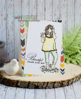 Card with Gianna Girl colored in a soft yellow top and mint jeans, 'Beautiful inside and out' stamped below her, matted over a chevron print strip and photographed with a white ceramic bird.