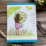 Soft watercolor scene with green trees and a blue sky, the girl in a pink skirt under her lace umbrella in a wildflower meadow, the Hebrews faith verse stamped at the right.