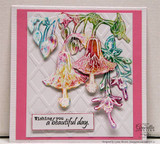 Rainbow-colored die-cut blooms cascading down a pink lattice-embossed card, captioned "Wishing you a beautiful day."