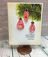 Card with red ornaments hanging from a pine bough and "May this Winter bring peace & serenity"