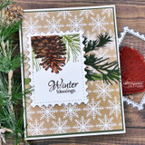 Card with a pinecone and pine bough on snowflake paper and "Winter blessings"