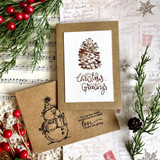 Card with a pinecone on music paper and a snowman-stamped envelope and "Christmas Greetings"