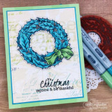 Aqua and green card with a script background, the wreath coloured in teal and blue with a green bow, copic markers alongside, sentiment 'It's Christmas rejoice & be thankful'.