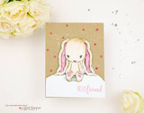 Handmade card featuring the floppy-eared Cuddlebug bunny sitting sweetly, on floral patterned paper, stamped with 'Hoppy Birthday'.