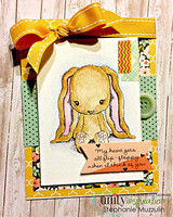 Handmade card featuring the floppy-eared Cuddlebug bunny sitting sweetly, on soft green grass strips, stamped with 'Hi friend'.