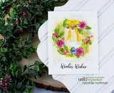 The wreath with a golden bow, pink blooms and a little bird on a white card, reading 'Warmest Winter Wishes.'