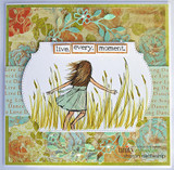 Handmade card of the girl in tall grass colored soft green, layered on floral paper with a 'live. every. moment.' banner.