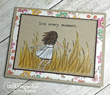 Card with the girl standing in golden grass on a kraft panel, sentiment 'live. every. moment.'