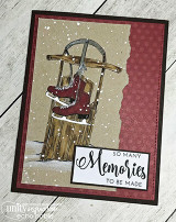 White-wash wood and burgundy card featuring the sled with deep red skates, snow flecks scattered across the panel and the sentiment on a crisp white strip.