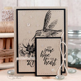 Kraft card with the hummingbird and flower stamped in black on stitched panels, accented with clear droplets and twine, lettered 'keep some hope in your heart.'