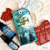 Pine-tree-and-music scene in teal on a tag with a moon.