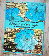 Bold mixed-media card with teal magnolias on a gold brick background, 'don't give up, so many people love you.'