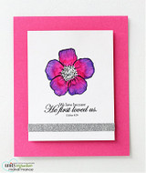 Pink card with a single flower colored magenta and purple, 'We love because He first loved us'