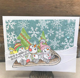 Handmade winter card of the three snowmen on a sled over a snowflake background with 'have a dashing good holiday.'