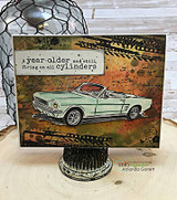 Card with a mint convertible on grungy industrial papers and "A year older and still firing on all cylinders"