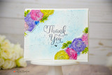 Card of a bright floral cluster with "Thank You" on a cake stand.