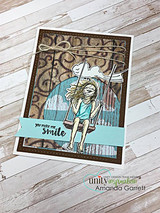 Ornate kraft card with the girl swinging on a white panel and a teal 'smile' sentiment strip.