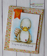 Card on white wood with polka dot paper and an orange flag, the platypus colored in soft yellow holding a wrapped gift, and "to my one of a kind friend" on a white strip.