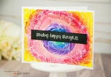 Card with the rose background blended in rainbow alcohol inks, crossed by a black 'sending happy thoughts' strip.