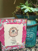 Pink floral card with Angie Blom's wild-feathered cartoon bird, 'I love you.'