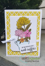 Yellow and pink flowers in a white teacup on a white card with yellow quatrefoil paper and a bow, stamped 'all we need is love...and coffee'.