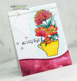 Red and orange flowers in a yellow mug on a white and burgundy watercolor card with a kind script greeting and twine.