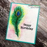Watercolor peacock feather in green, blue and pink on a teal-framed card with the sentiment 'Happy Birthday'