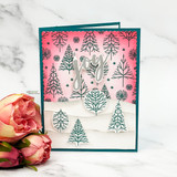 Card with a snowy pine-tree scene and 'joy.'