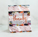 A dark floral card with copper embossed leaves across the front and 'thanks' heat embossed in copper on a vellum strip.