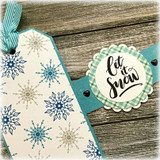 Snowflake-covered tag with a green 'let it snow' medallion.