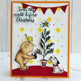 Red-and-orange card with the bear hanging an ornament on the tree beneath a starry banner.