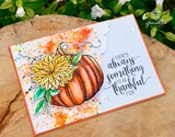 Handmade card made with Unity Stamp Co’s Faith Family Fall red rubber stamp set — a pumpkin topped with a big fall chrysanthemum bloom — stamped and colored, with the sentiment “There’s always something to be thankful for”.