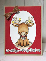 Handmade card made with Unity Stamp Co’s Santa's Lil Helper Cuddlebug red rubber stamp set — a wide-eyed baby reindeer with tiny ornaments hanging from its antlers and a bell collar — stamped and colored, with the sentiment “We wish you a Merry Christmas”.
