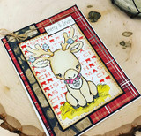 Handmade card made with Unity Stamp Co’s Santa's Lil Helper Cuddlebug red rubber stamp set — a wide-eyed baby reindeer with tiny ornaments hanging from its antlers and a bell collar — stamped and colored, with the sentiment “We wish you a Merry Christmas”.