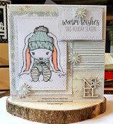 Soft gray and peach bunny in a knit hat on a neutral layered card with snowflakes, a wood NOEL and 'warm wishes this holiday season'.