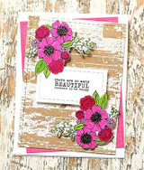Card with the barn wall in kraft tones behind pink flowers: 'there are so many beautiful reasons to be happy.'