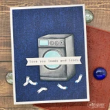 The denim background behind a stamped washing machine with tumbling socks on a blue card.