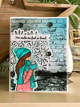 Card with the cozy girl in teal and coral over a blue brick background and 'You make me feel so loved.'